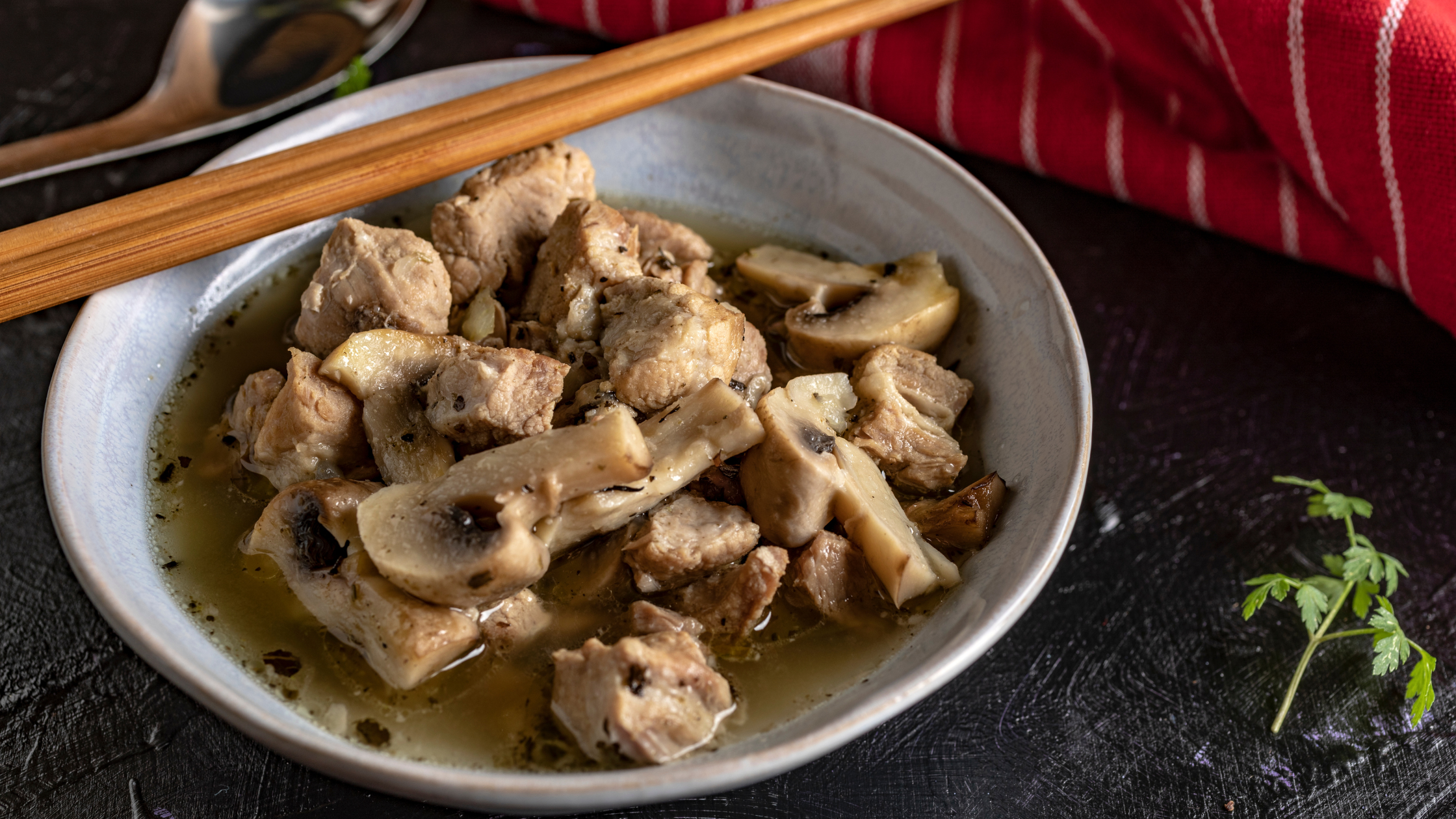 Pork fillet with mushroom sauce in a bowl with chopsticks