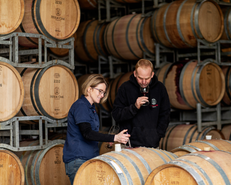 Bec Duffy and Tim Duffy look at Pinot Noir in the barrel hall