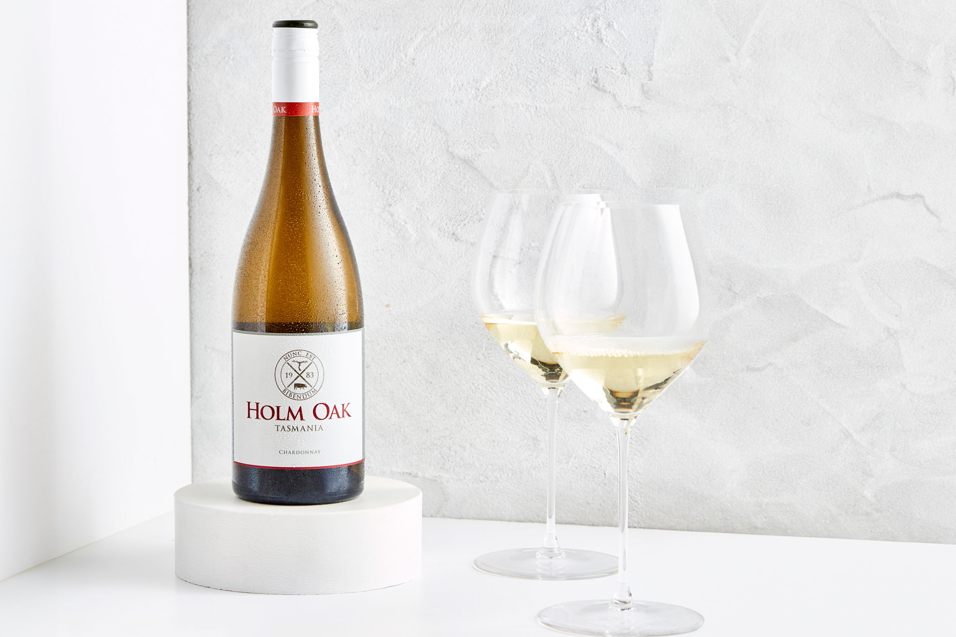 A bottle of Holm Oak Estate Chardonnay with two glasses of wine poured